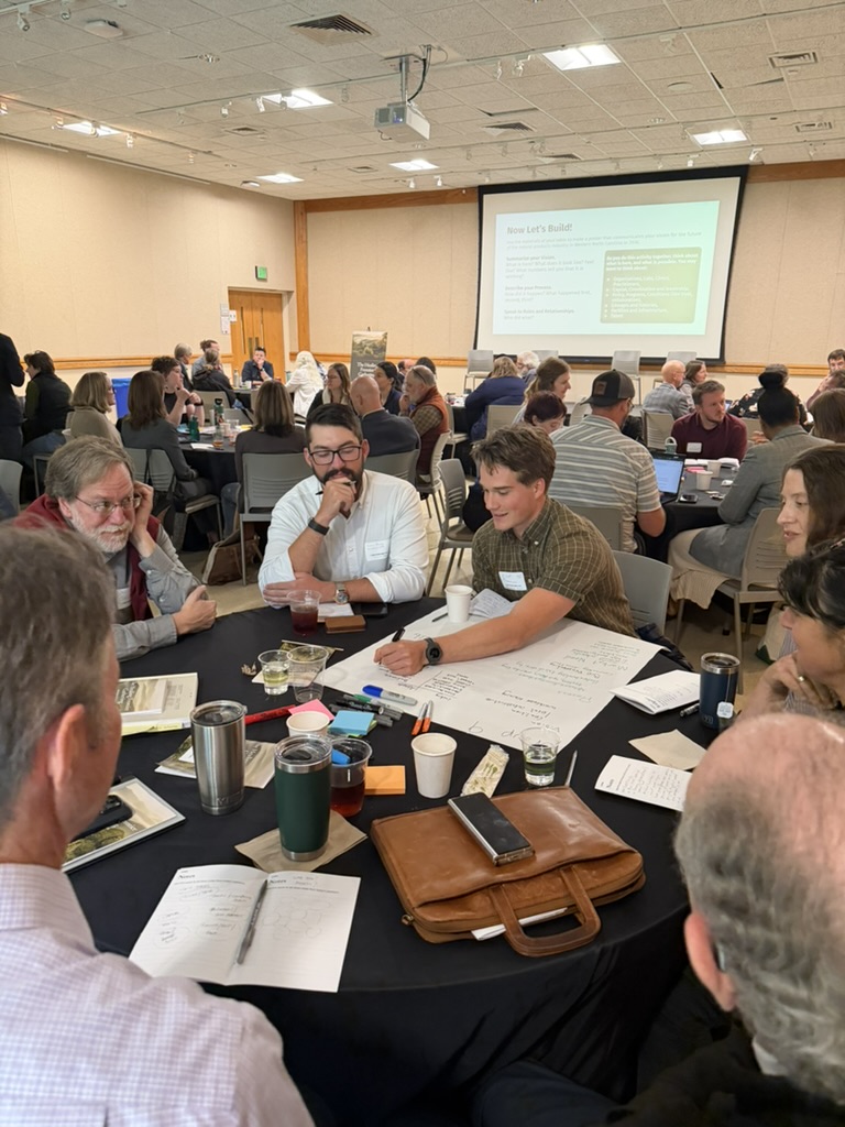 Attendees in small-group discussion around a table